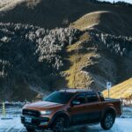 a red truck parked in front of a mountain